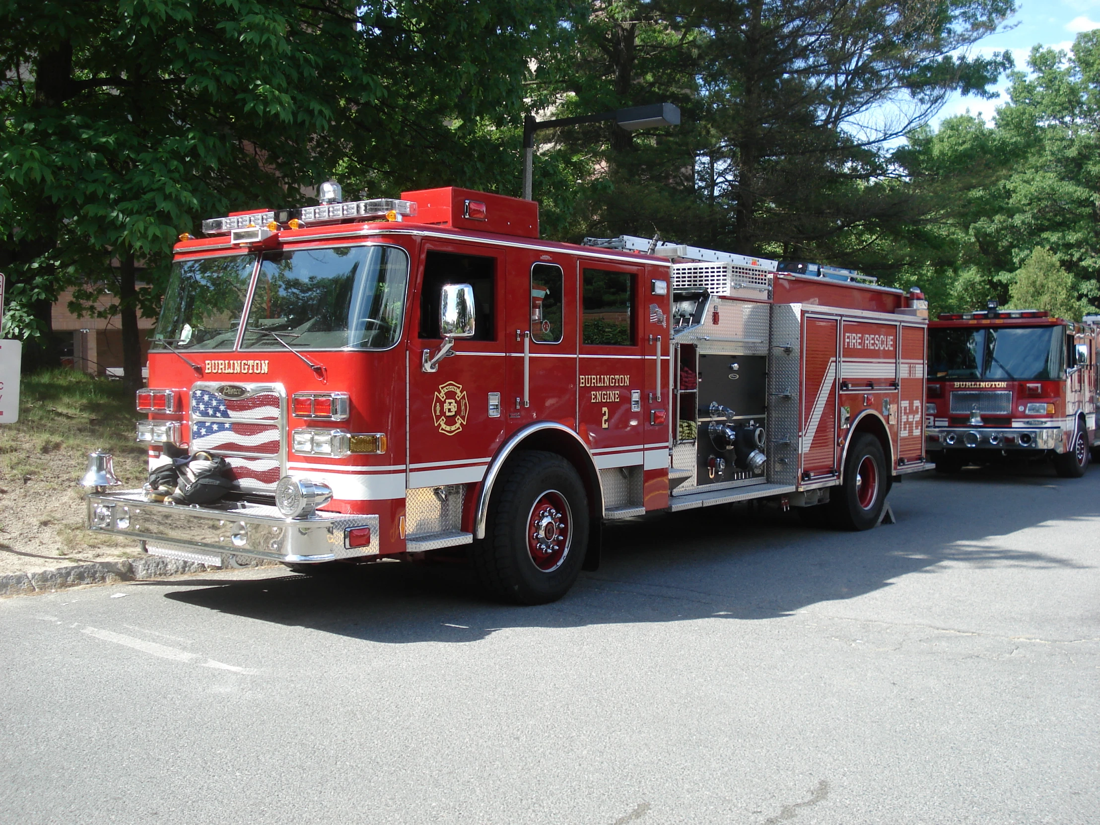 several red fire trucks are parked on the side of the road