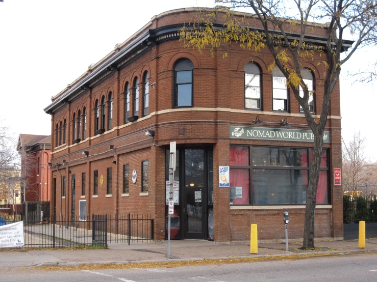 a red brick building with windows near a parking lot