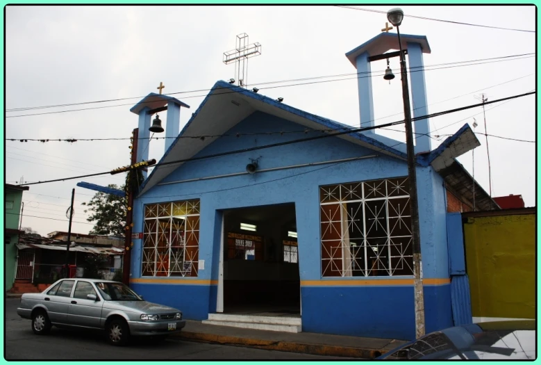 the car is parked in front of the blue church