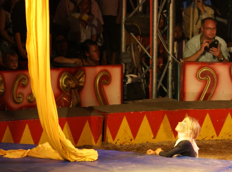 a small child on the floor is watching people on stage