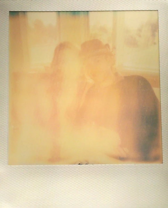a polaroid pograph of people sitting with one laying down
