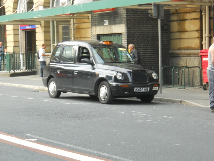 a black cab is stopped on the side of the road