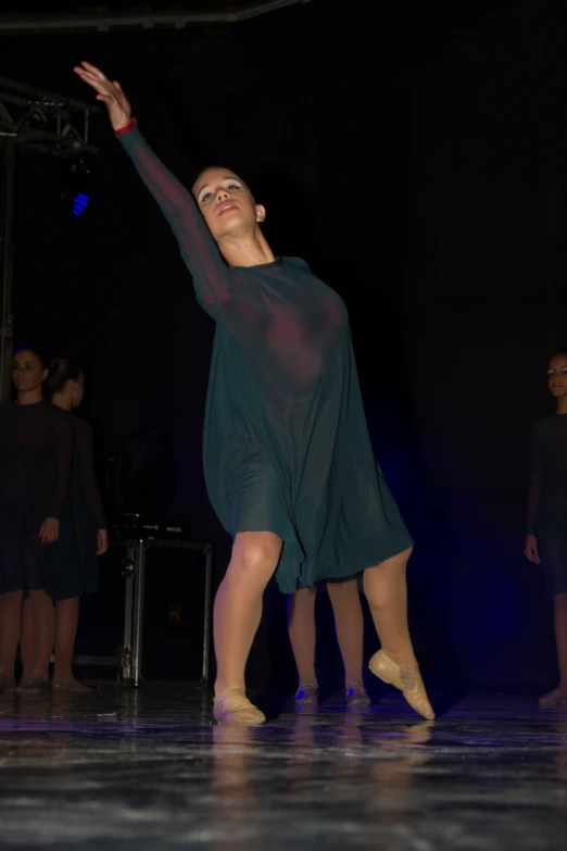 a woman is standing and dancing in a black dress