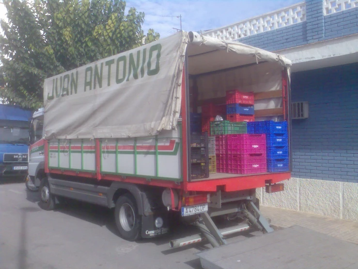 an open truck carrying supplies down the street