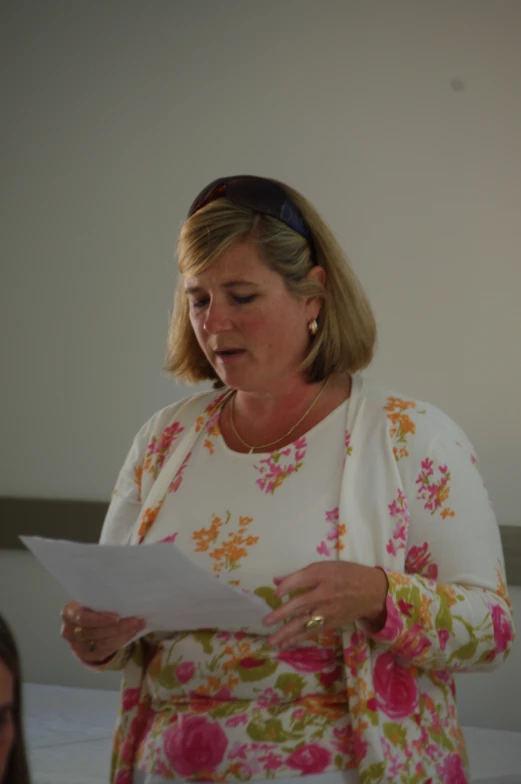 a woman standing on top of a bed while reading a piece of paper