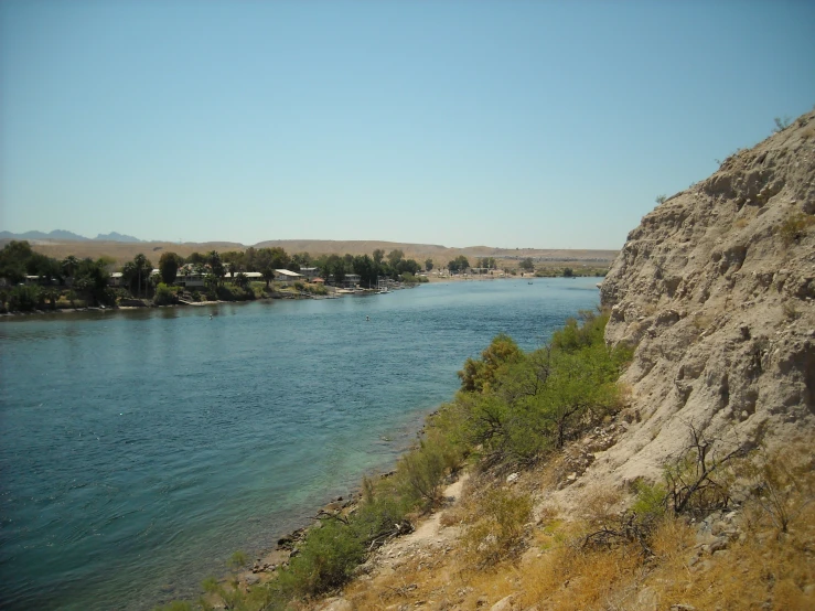 a body of water with some trees and a hill