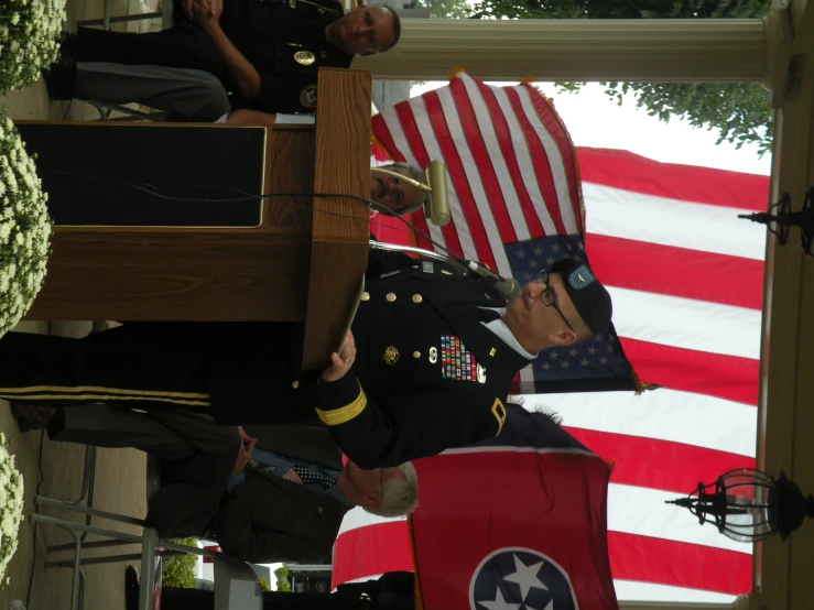 a soldier saluting a soldier carrying a flag in a shrine