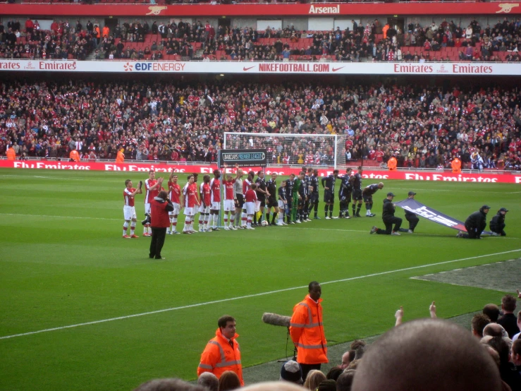 an orange and black soccer team with the mascot and referees