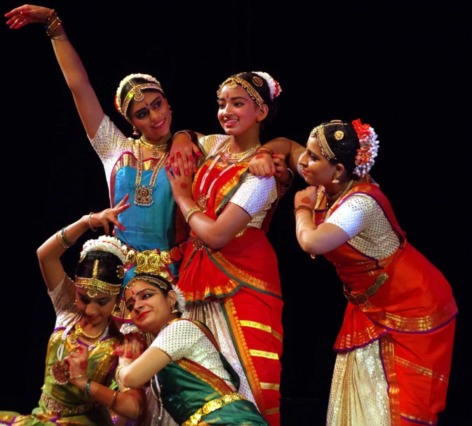 a group of women in indian dress dancing on stage