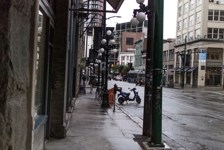 a motorcycle parked on the side of a wet sidewalk