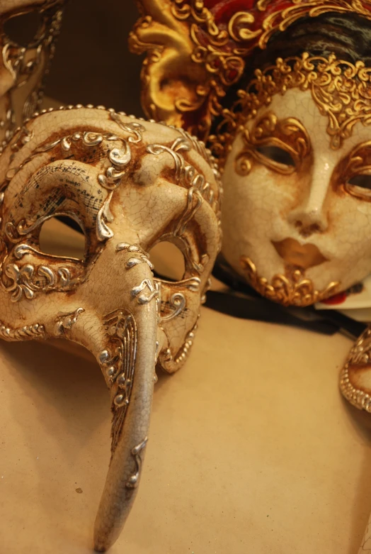 ornate mask hanging on wall next to other pieces