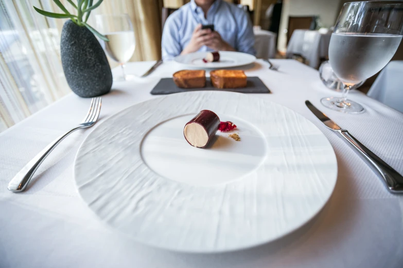 a plate topped with a small piece of food