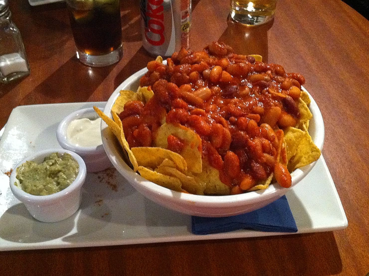 a platter of nachos and chips sitting on top of a table