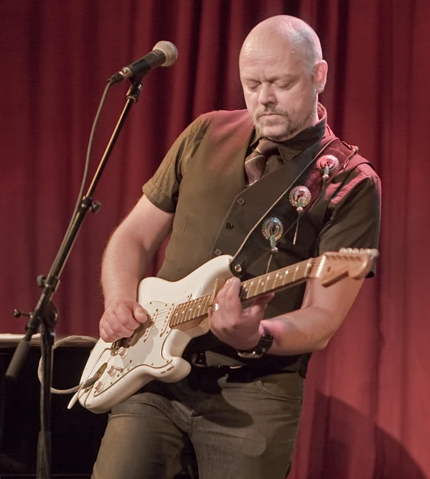 the man is playing an electric guitar on stage