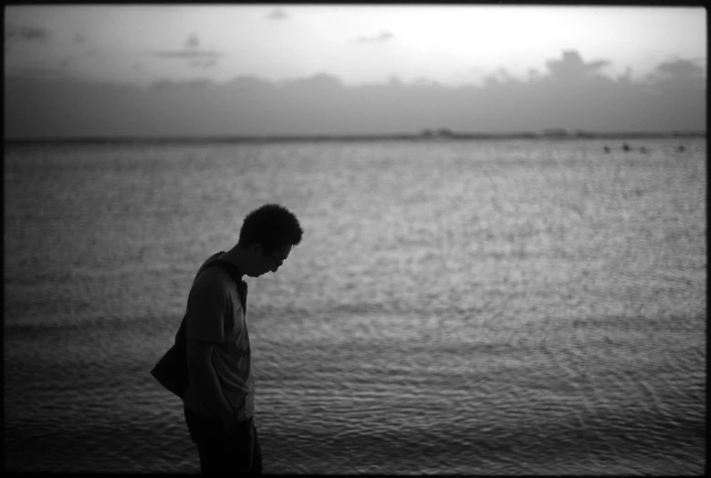 black and white image of a man by the ocean