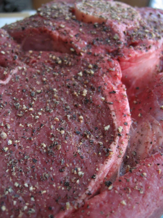 a piece of raw meat is shown with spices