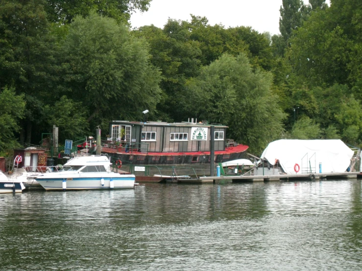 several boats parked next to a pier with covered areas near it