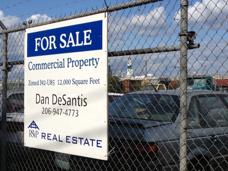 the gate is behind a sign announcing for sale