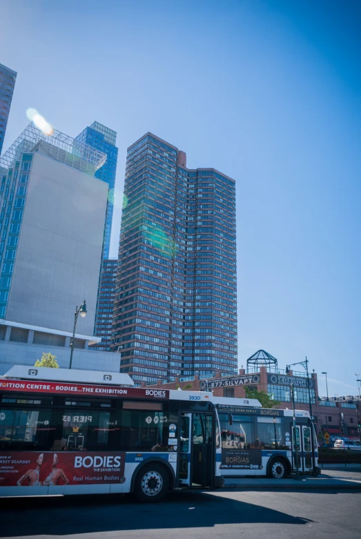 a city street lined with parked busses in front of tall buildings