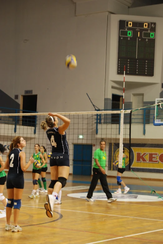 a group of young women playing a game of volleyball