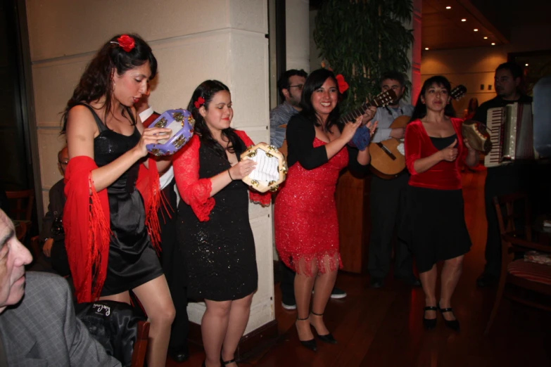 a bunch of ladies wearing red scarves singing together