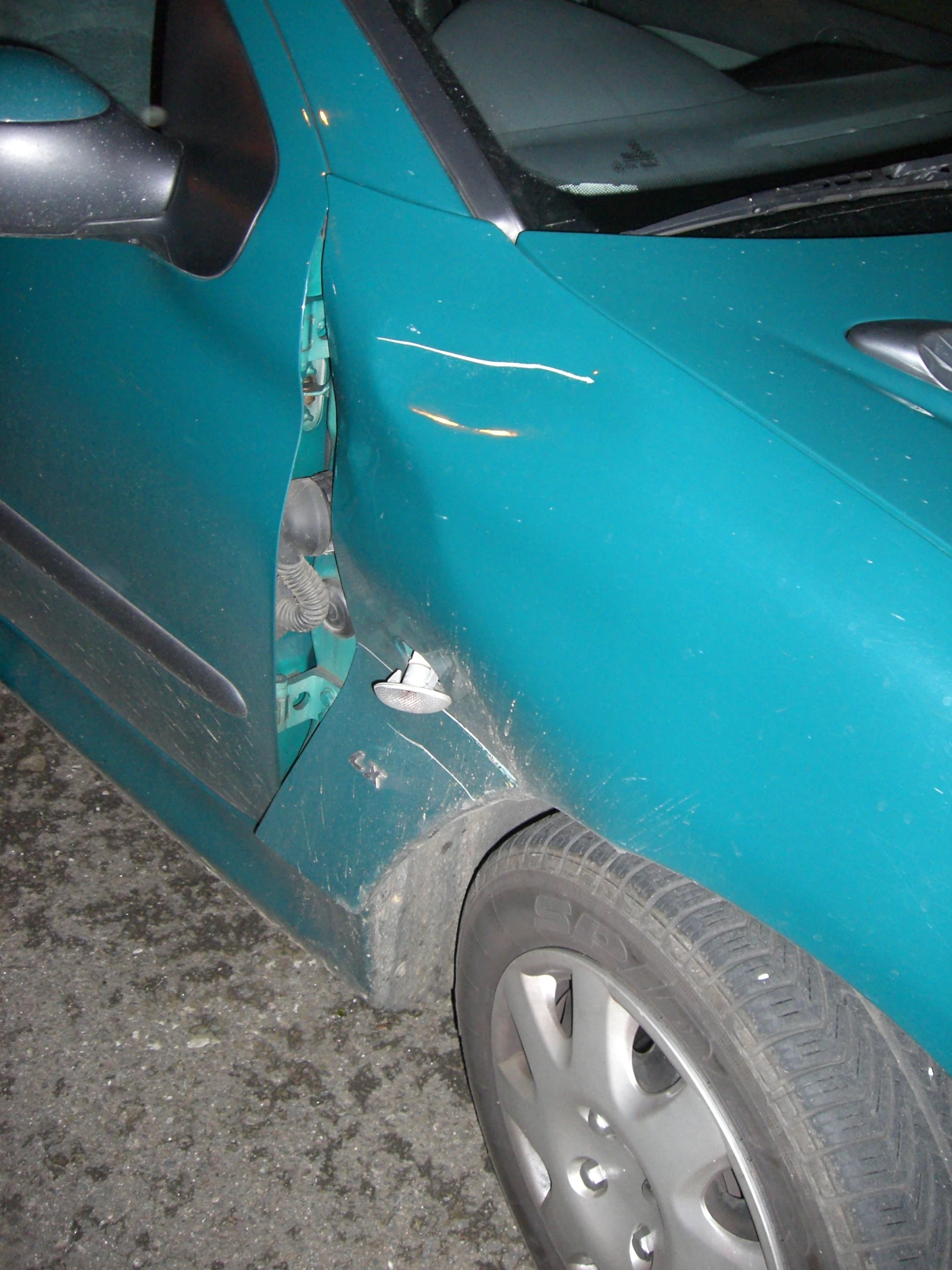 a damaged blue car with two windows and denting