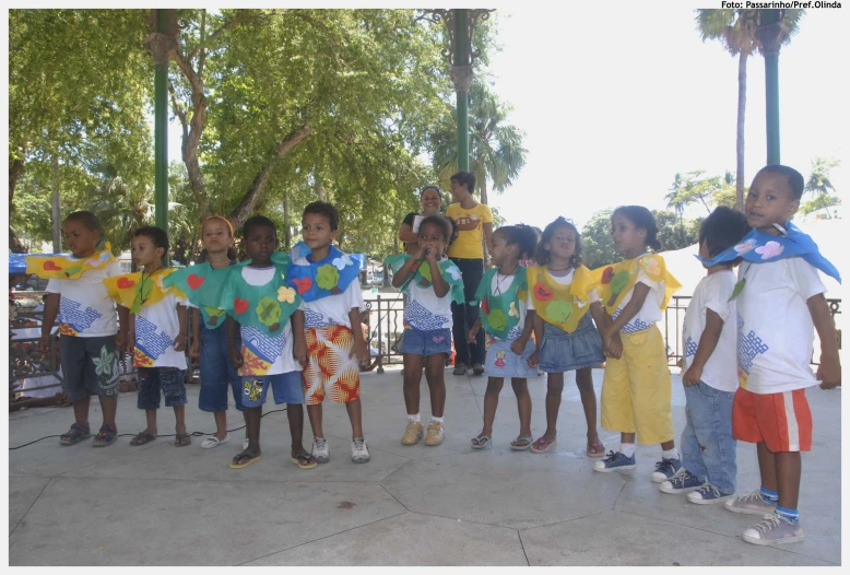 group of children are standing together on the pavement