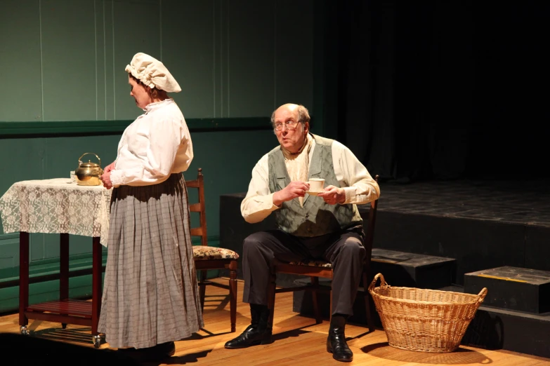 an old woman is standing near an older man at a table