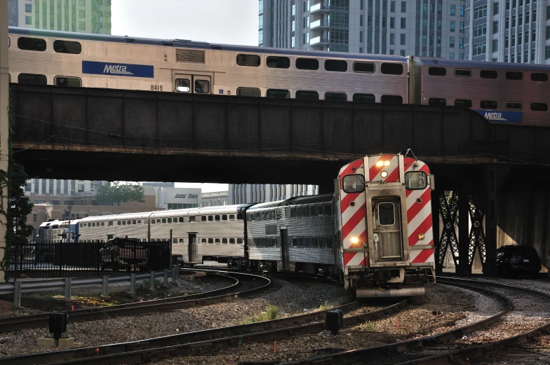 a train is pulling many cars under the bridge