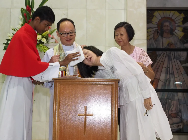 a catholic woman is at a pulpit with three other priests