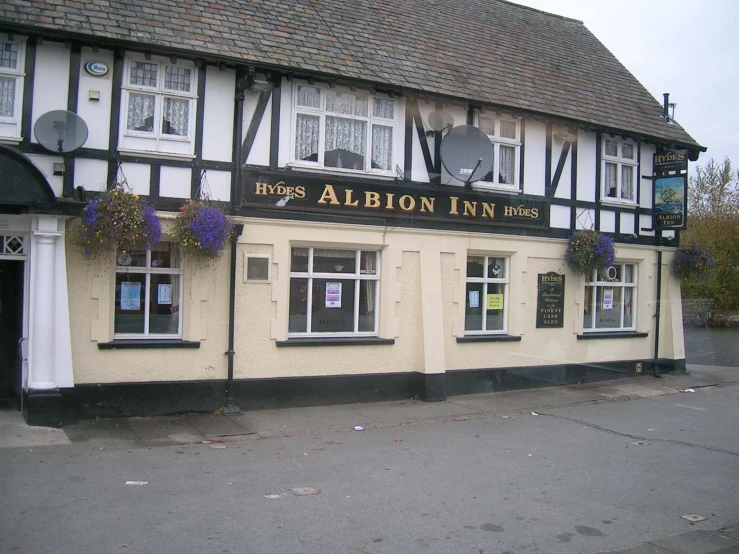 the front of the abion inn has flowers on the windows