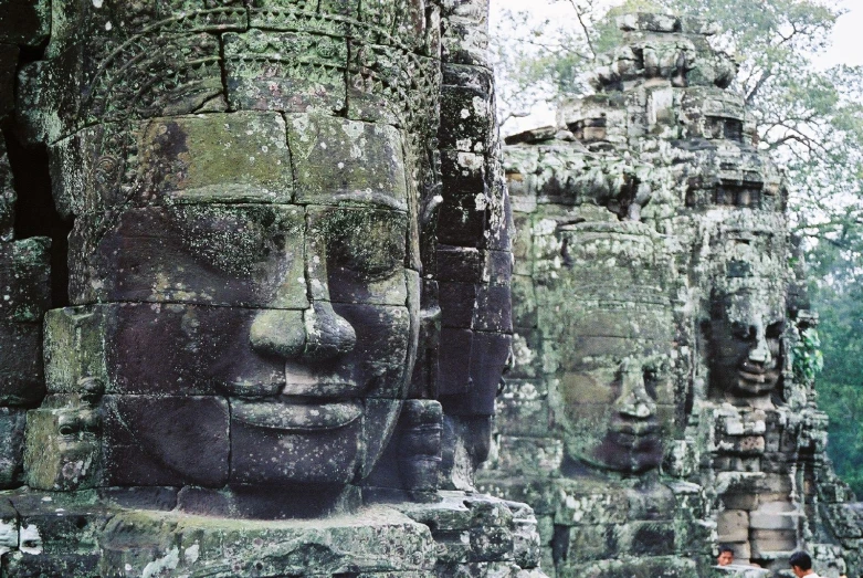 some very tall statues at the ruins of a building