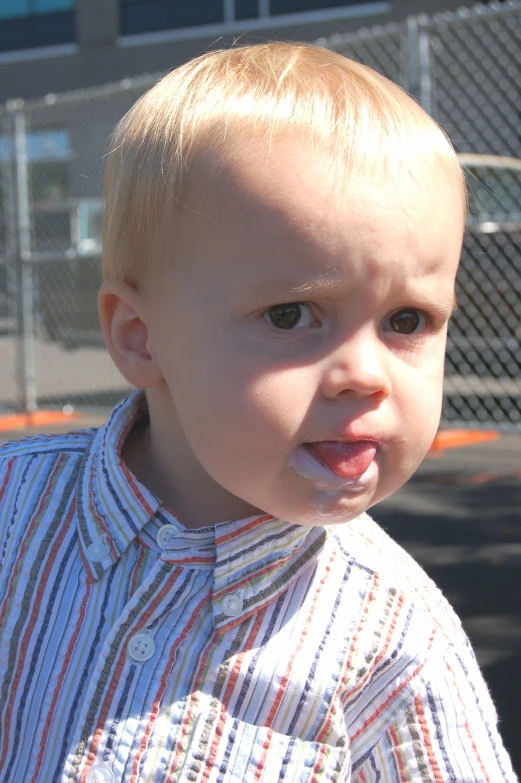 a  in  shirt with orange and blue toothbrush in his mouth