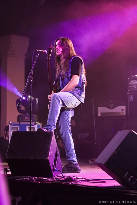 the man is playing his guitar in front of a stage