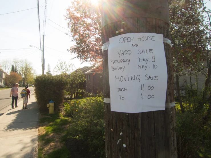 a sign posted to a wooden post on the side of a road