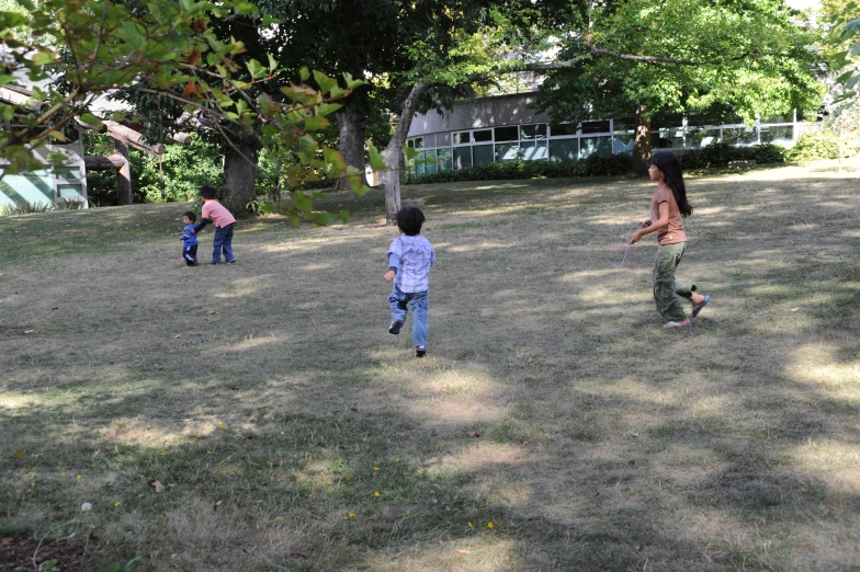 a group of people play with a frisbee in a yard