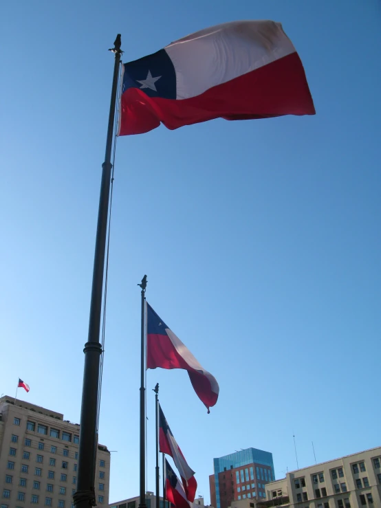 two large texas and texas state flags are flying