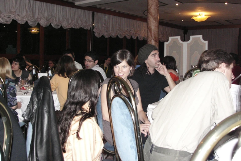 a group of people sitting and standing in a dining room