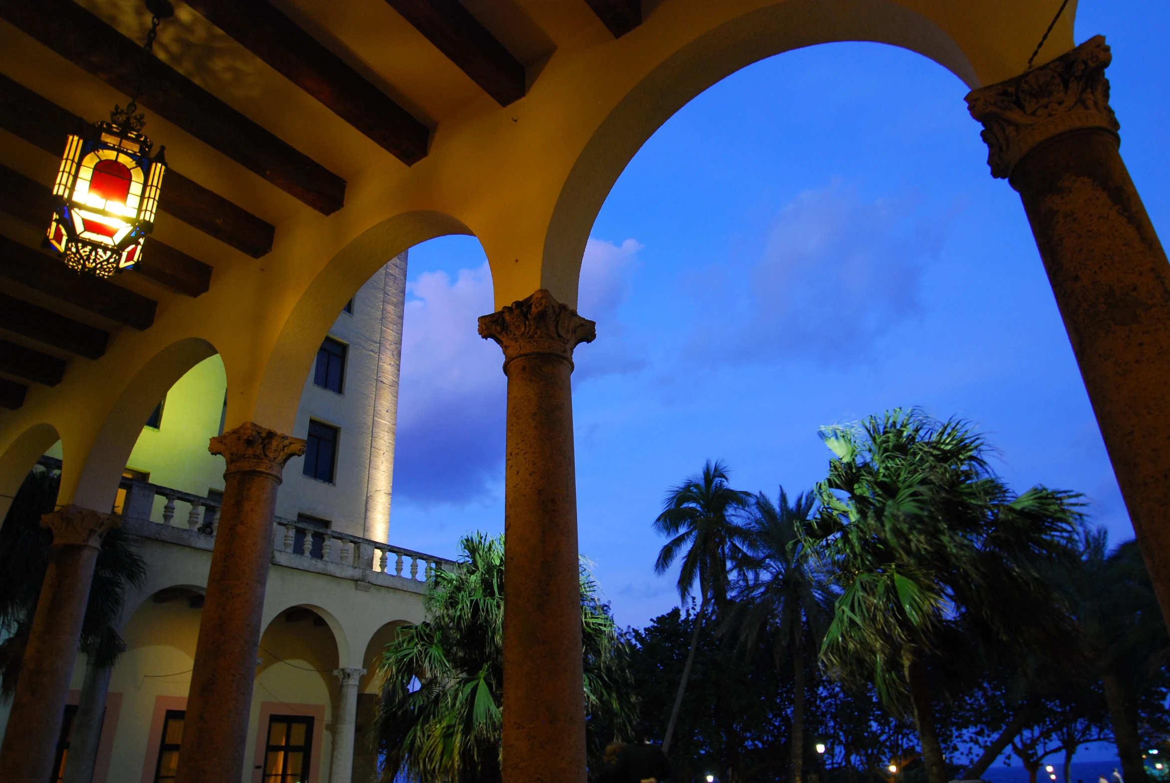 an arcade that has columns, arches and a clock tower in it