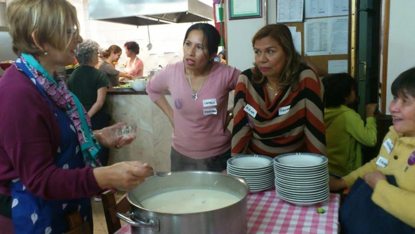 a bunch of ladies standing around and talking to a woman