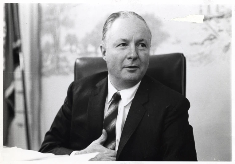 an older black and white po of a man wearing a suit