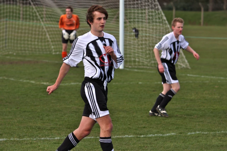 the soccer players in the uniforms are playing on the field