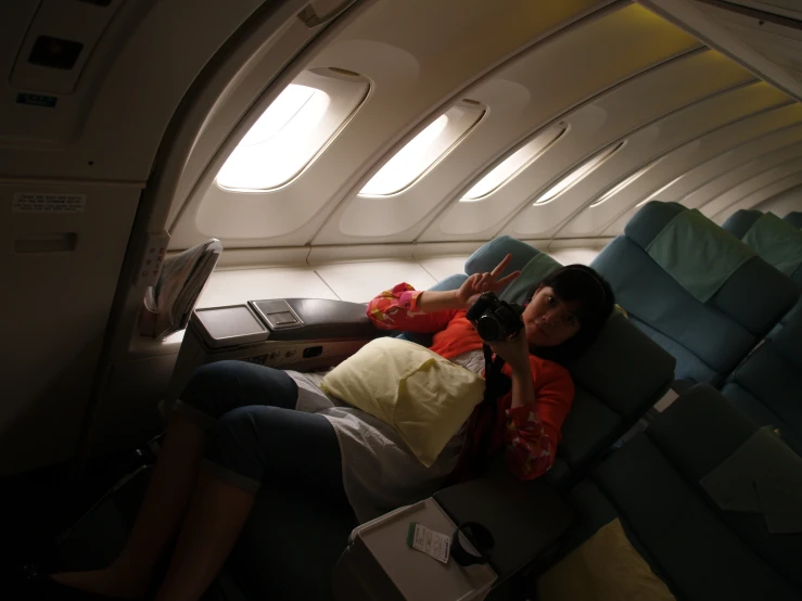 two people laying on a airplane near one another