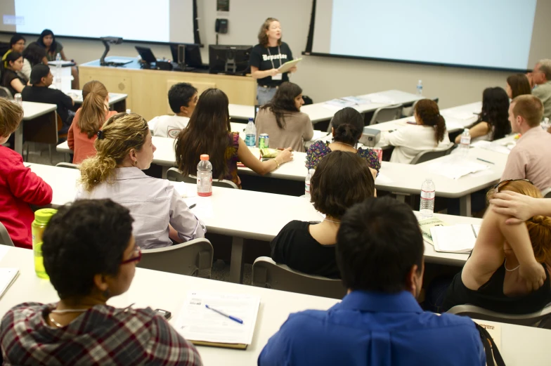 a group of people sitting in front of a projector screen