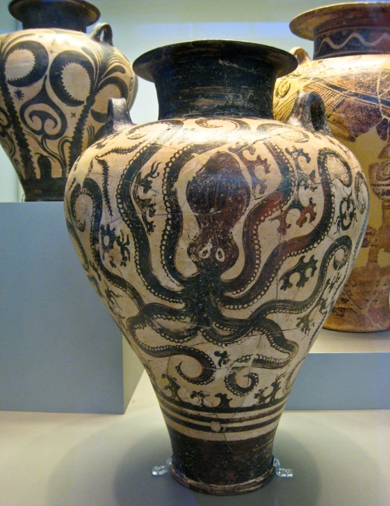 three urns with various patterns and designs are on display