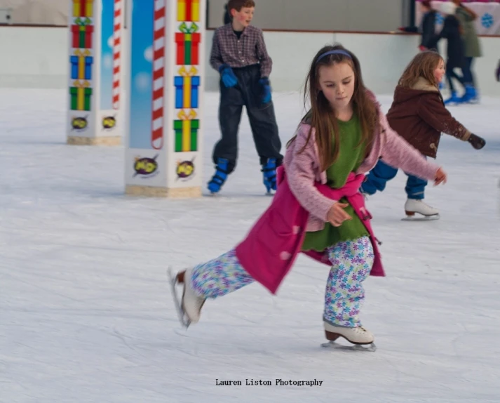 three children are playing on an ice rink