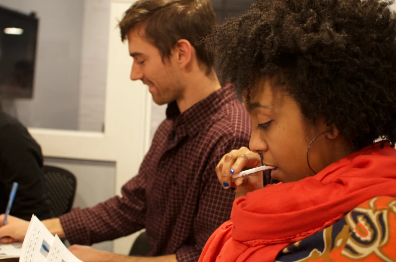 three people working on papers at a table