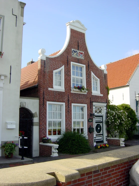 a brick building with lots of windows sits in the middle of a town square