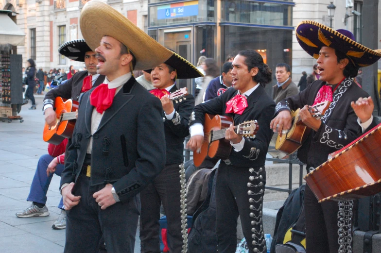 a group of musicians in mexican outfits and hats with musical instruments