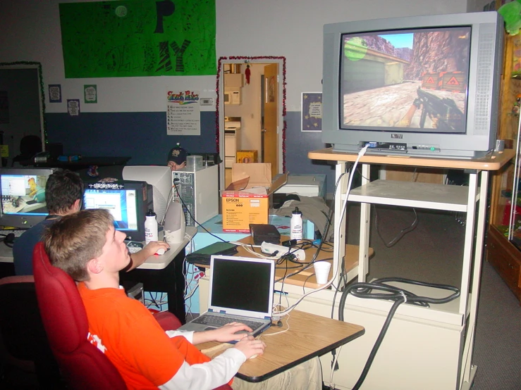 two boys playing a video game on computer monitors